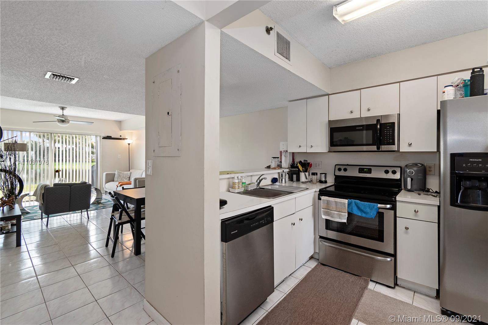 184 Riviera Circle, Unit 325 Weston, FL 33326 - Photo 9 of 27 a kitchen with stainless steel appliances a stove a sink and a refrigerator
