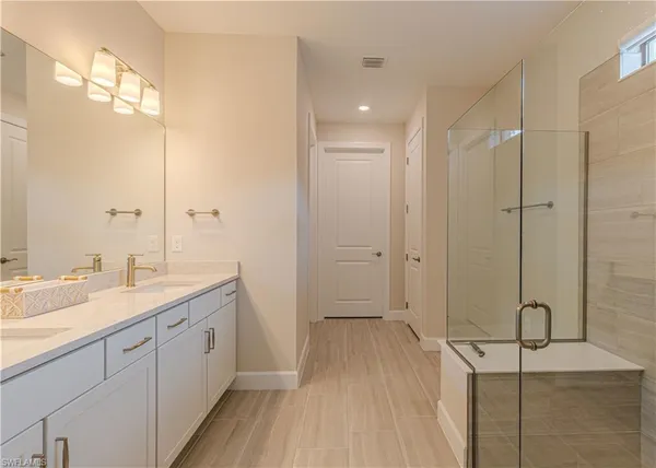 a bathroom with a granite countertop sink a mirror and a shower