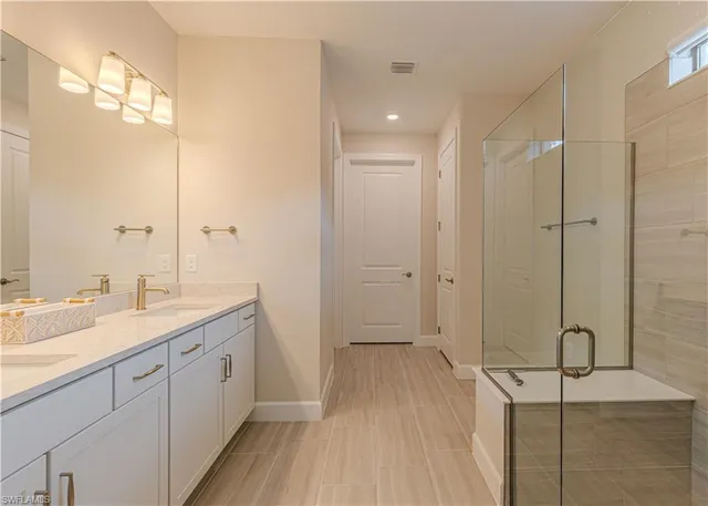 a bathroom with a granite countertop sink a mirror and a shower