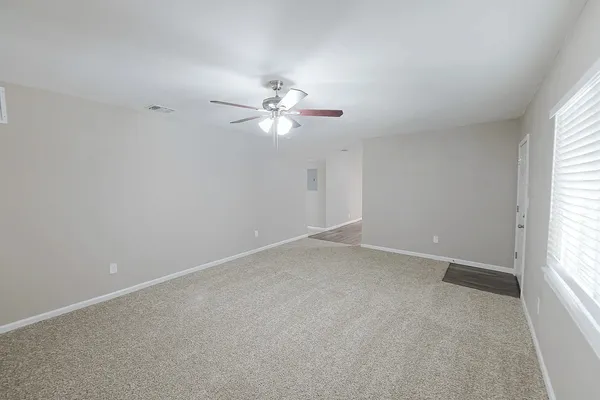 an empty room with a window and a ceiling fan