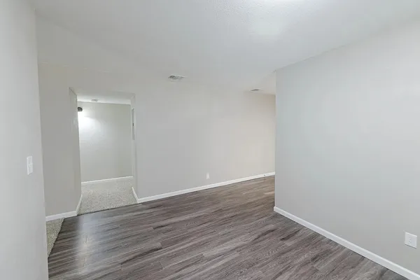 a view of an empty room with wooden floor