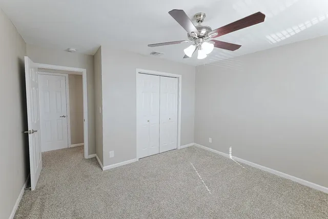 a view of an empty room with a ceiling fan
