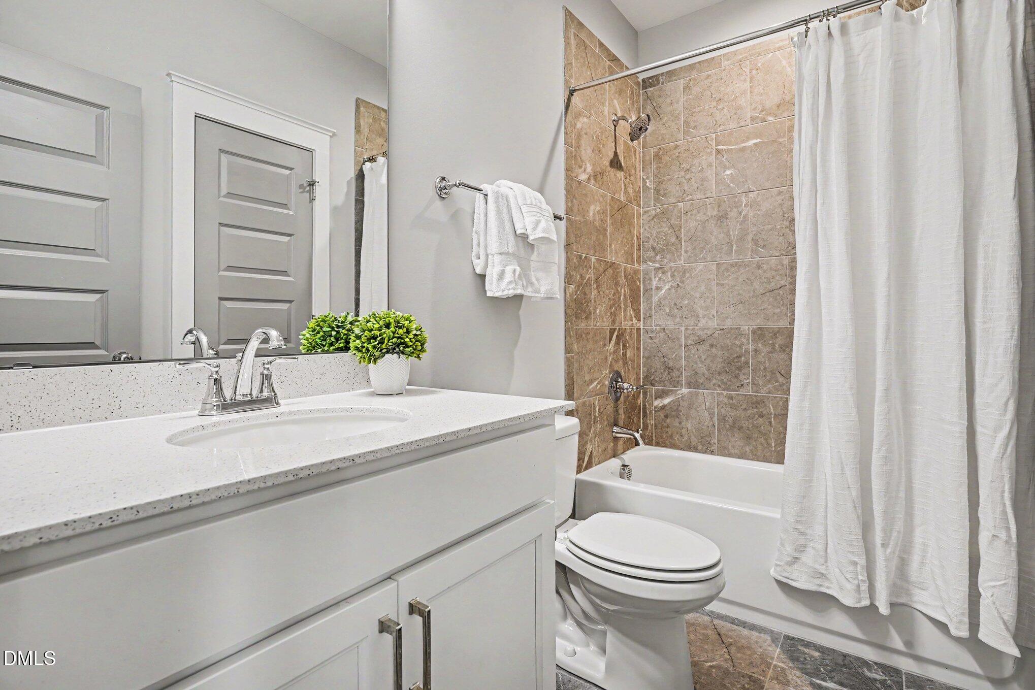 824 Watercolor Way Durham, NC 27713 - Photo 20 of 28 a bathroom with a granite countertop sink toilet and shower