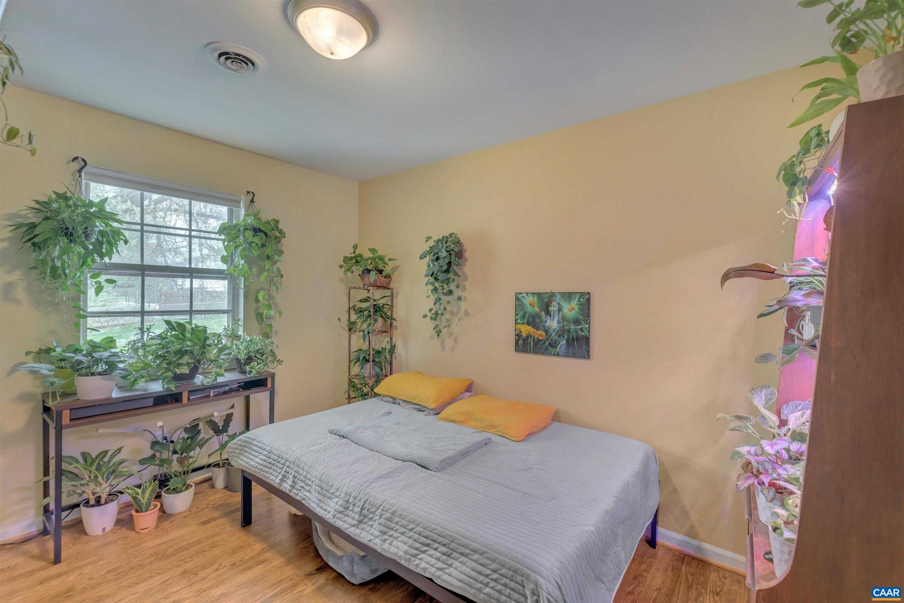 113 Summit Street, Unit 113 Charlottesville, VA 22903 - Photo 11 of 15 a bedroom with a bed and a potted plant