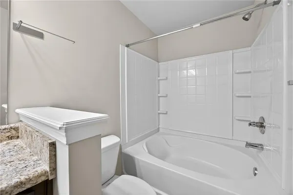 a white bath tub sitting next to a toilet