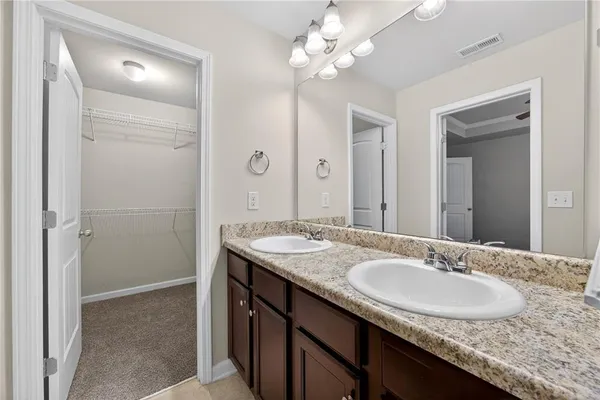 a bathroom with a granite countertop sink a light fixture and a mirror