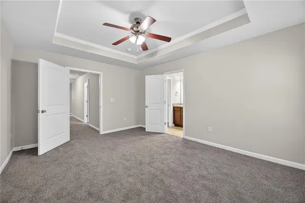 an empty room with fan ceiling fan and windows