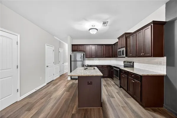 a kitchen with stainless steel appliances granite countertop a sink stove and refrigerator