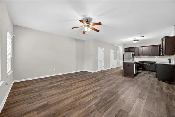 a view of open kitchen with wooden floor and a ceiling fan