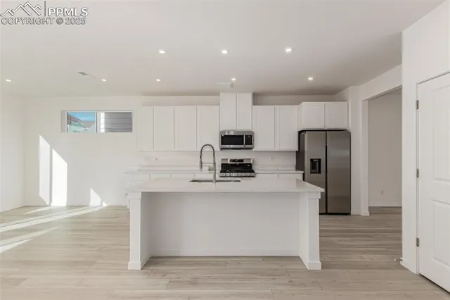 a kitchen with white cabinets stainless steel appliances and sink