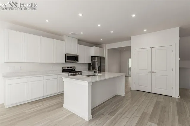 a kitchen with stainless steel appliances granite countertop a refrigerator sink and stove