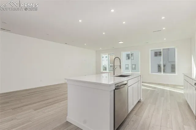 a kitchen with stainless steel appliances granite countertop a sink a stove a refrigerator and a oven