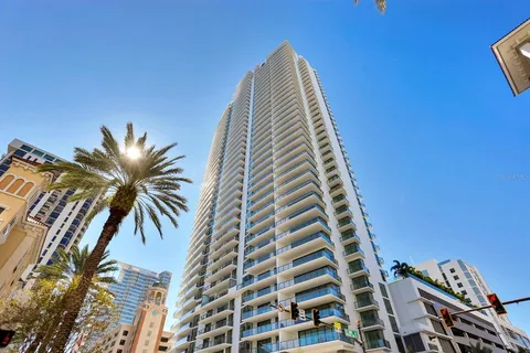a living room with furniture a large window and wooden floor