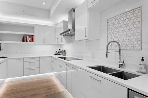 a view of a hallway with wooden floor and furniture