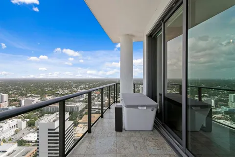 a dining room with furniture and a floor to ceiling window