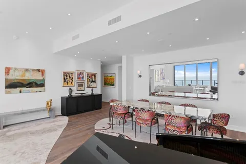 a large living room with stainless steel appliances granite countertop couches a fireplace and a flat screen tv