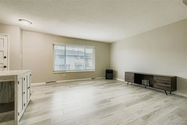 a view of an empty room with a fireplace and a window