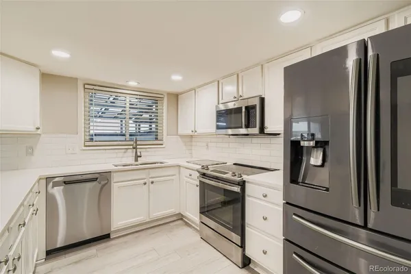 a kitchen with white cabinets stainless steel appliances and sink