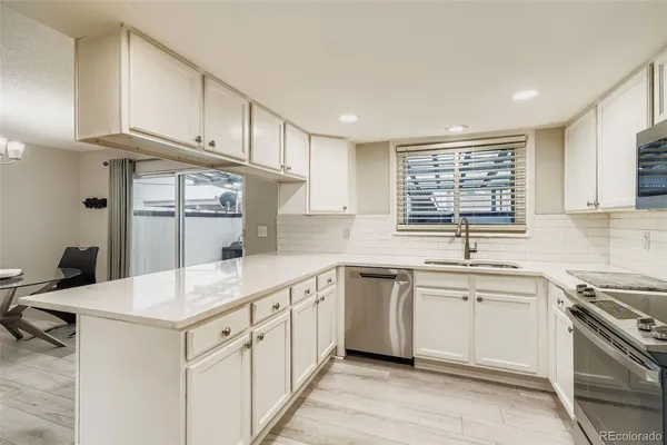 a kitchen with white cabinets appliances and sink