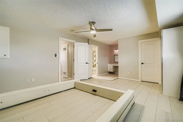 a view of an empty room with window and a kitchen