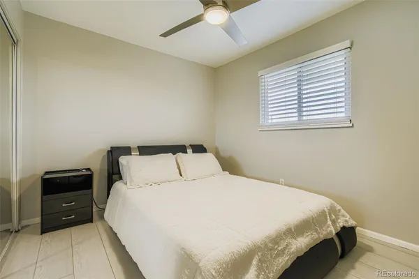 a bedroom with a bed and a ceiling fan