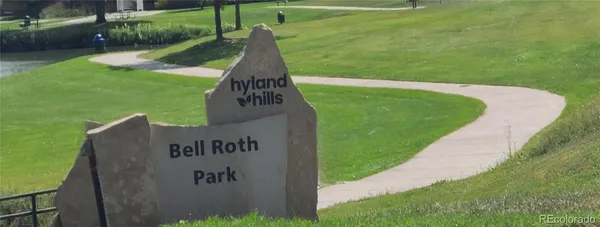 a view of a lake with a yard and large trees