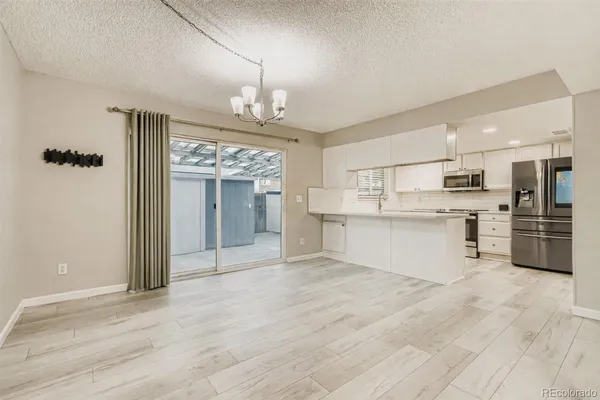 a view of kitchen with granite countertop cabinets and refrigerator