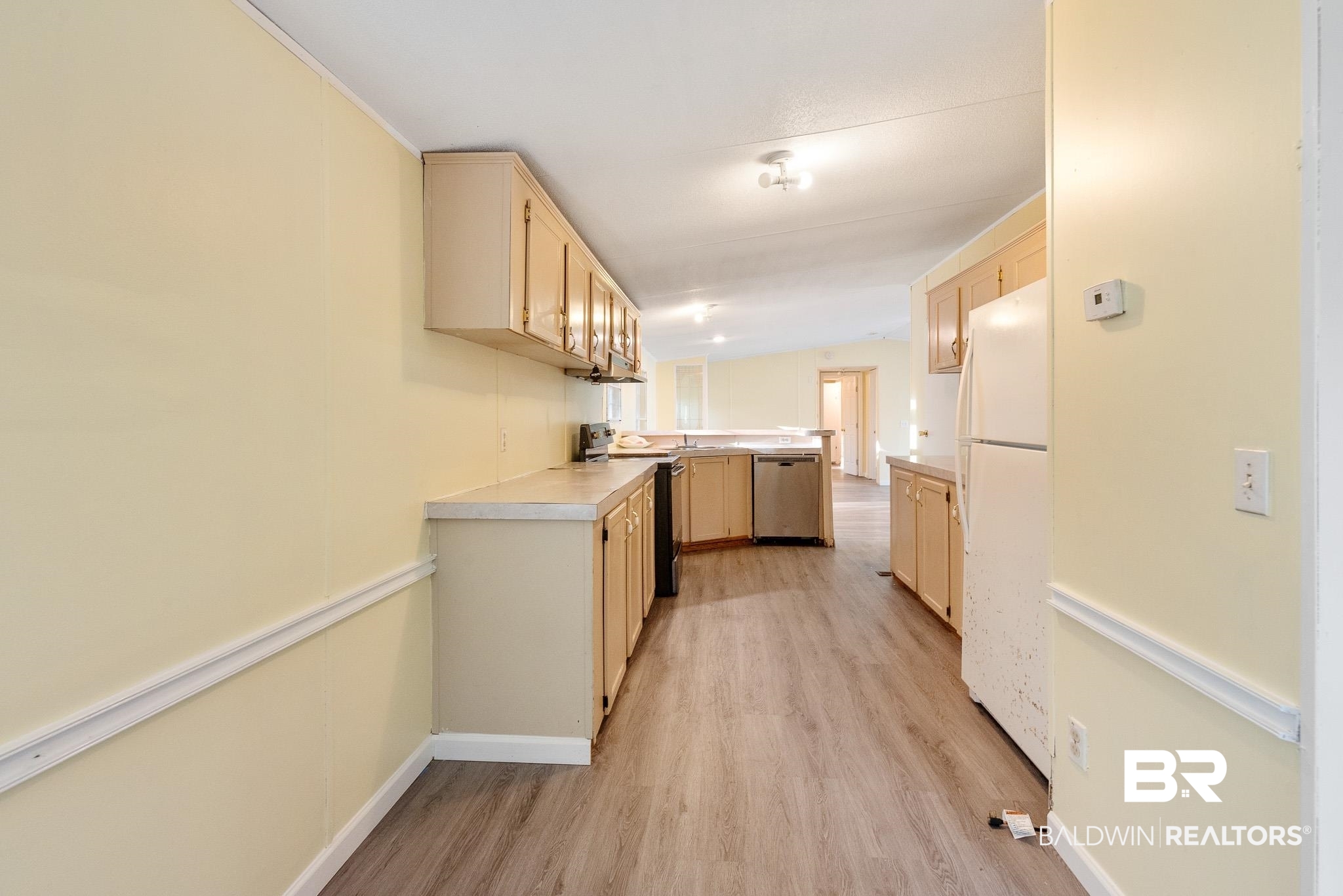 7695 Bermuda Drive Semmes, AL 36575 - Photo 13 of 27 Kitchen with a peninsula, light wood-style flooring, light brown cabinetry, stainless steel appliances, and light countertops