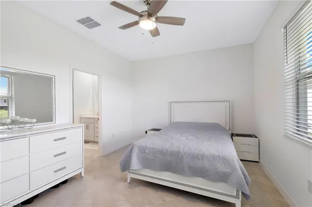 a room with a bed and a double vanity sink