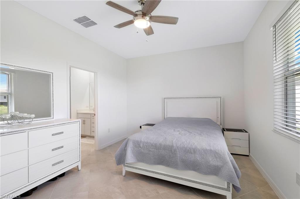 2052 Vermont Lane Naples, FL 34120 - Photo 13 of 35 a room with a bed and a double vanity sink