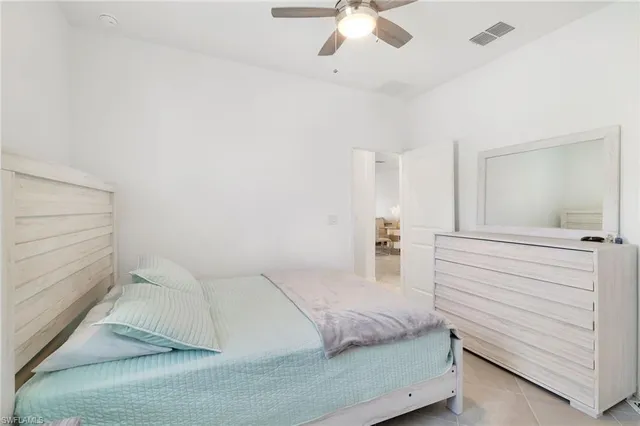 a bedroom with a large bed and chandelier