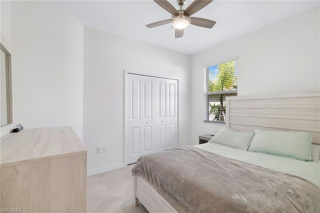 2052 Vermont Lane Naples, FL 34120 - Photo 17 of 35 a bedroom with a bed and a chandelier