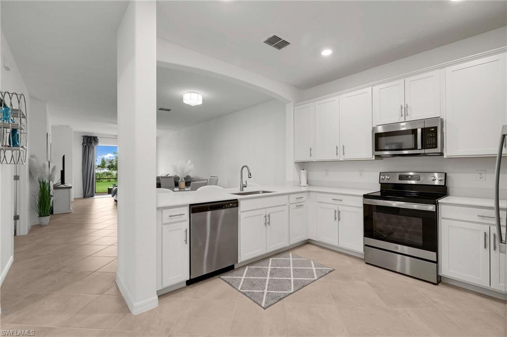 2052 Vermont Lane Naples, FL 34120 - Photo 6 of 35 a kitchen with sink a microwave and cabinets