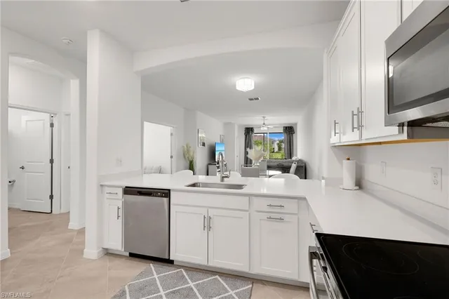 a kitchen with white cabinets appliances and sink