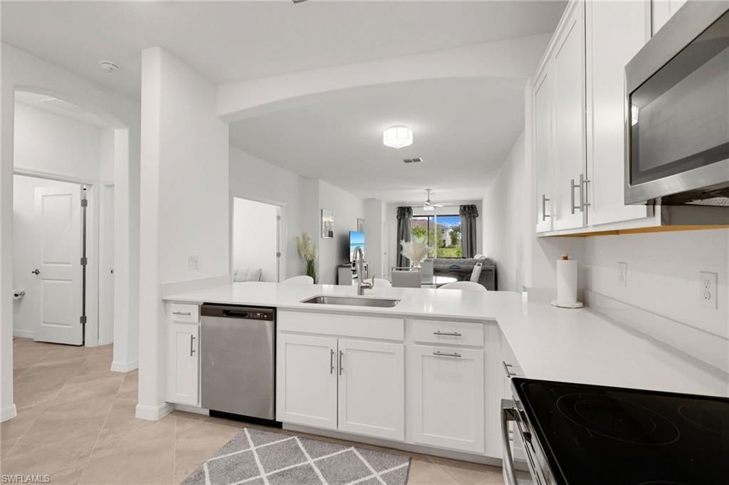 2052 Vermont Lane Naples, FL 34120 - Photo 8 of 35 a kitchen with white cabinets appliances and sink