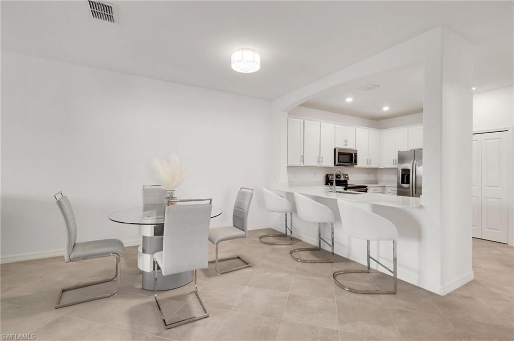 2052 Vermont Lane Naples, FL 34120 - Photo 9 of 35 a kitchen with white cabinets and white appliances