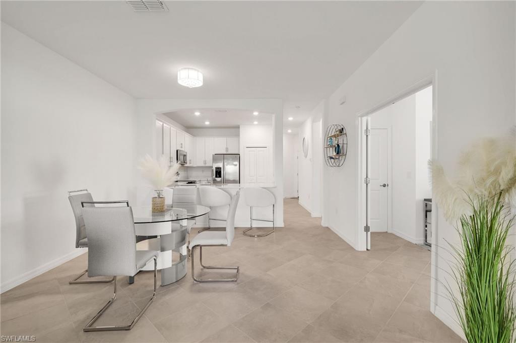 2052 Vermont Lane Naples, FL 34120 - Photo 10 of 35 a living room with furniture a dining table and chairs