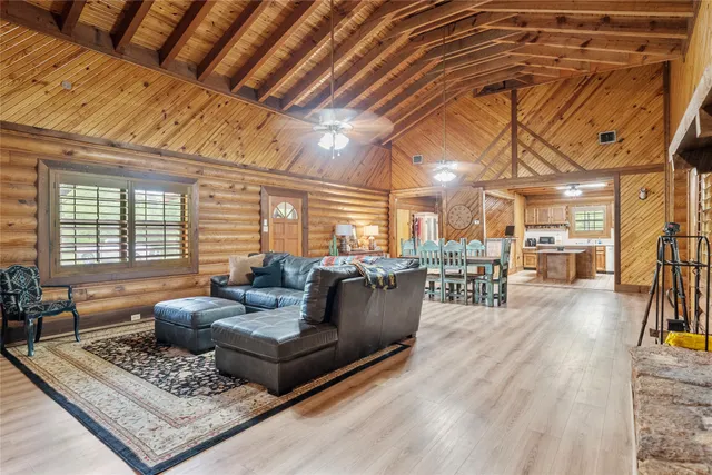 a view of a patio with table and chairs a barbeque with wooden floor and fence