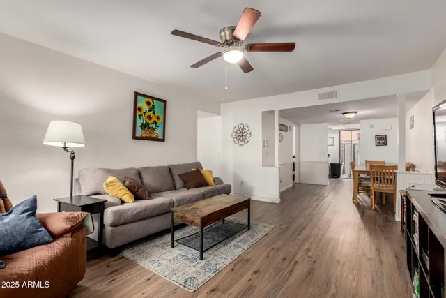 a living room with furniture and a wooden floor