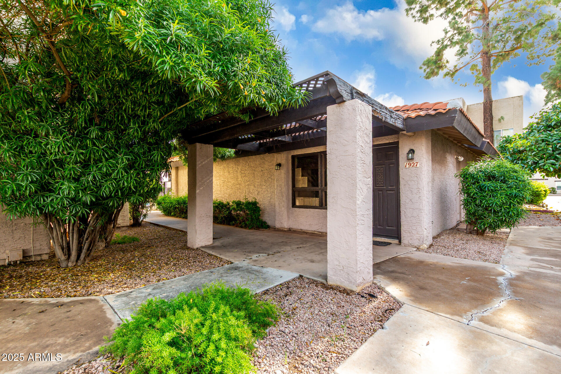 1927 East Hampton Avenue, Unit 129 Mesa, AZ 85204 - Photo 23 of 23 a view of a wooden house with a small yard and large tree