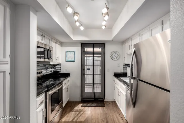 a kitchen with stainless steel appliances a refrigerator a stove a sink and a refrigerator