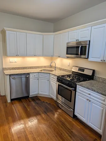 a view of a kitchen with stainless steel appliances granite countertop a stove a sink and a microwave