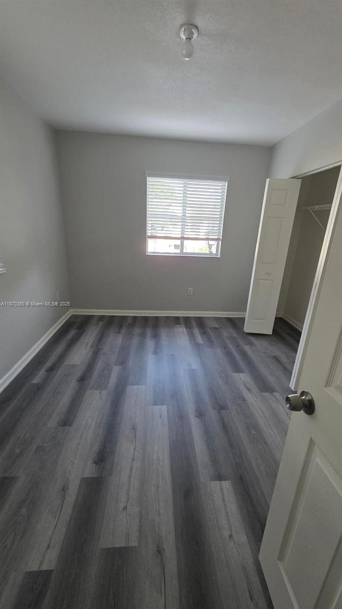 2748 Southwest 83rd Avenue, Unit 108 Miramar, FL 33025 - Photo 16 of 20 an empty room with wooden floor and windows
