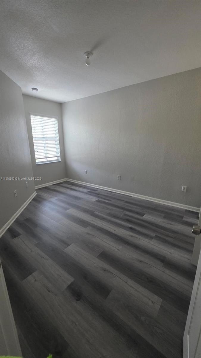 2748 Southwest 83rd Avenue, Unit 108 Miramar, FL 33025 - Photo 17 of 20 a view of an empty room with wooden floor and a window