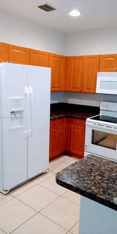 a black white refrigerator freezer sitting inside of a kitchen