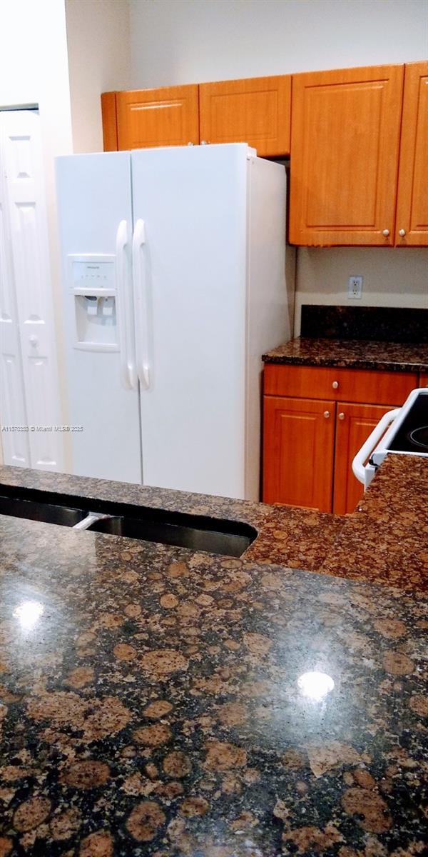 2748 Southwest 83rd Avenue, Unit 108 Miramar, FL 33025 - Photo 7 of 20 a black white refrigerator freezer sitting inside of a kitchen