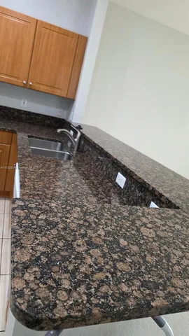 a kitchen with stainless steel appliances granite countertop a sink and a stove