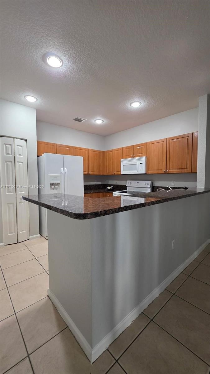 2748 Southwest 83rd Avenue, Unit 108 Miramar, FL 33025 - Photo 9 of 20 a kitchen with stainless steel appliances granite countertop a sink and a stove