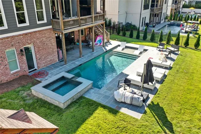 a living room with furniture large windows and wooden floor