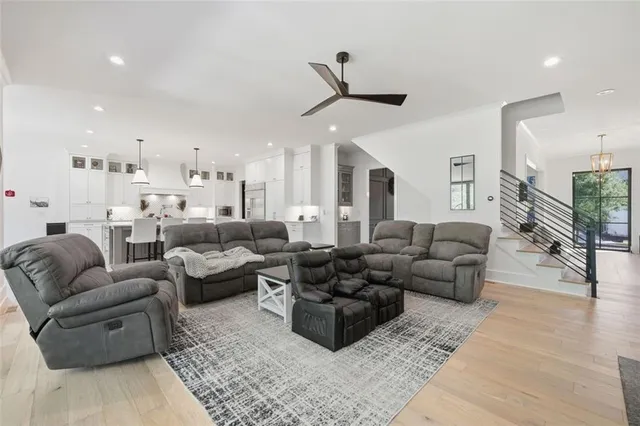 a kitchen with stainless steel appliances kitchen island granite countertop a dining table chairs and a white refrigerator